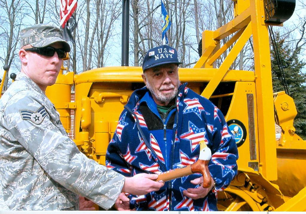 Senior Airman Joseph Moderacki presenting cane to CMM Raymond Goeller, U.S.N. Retired. Cane carved by Hal Weise of HVWC.