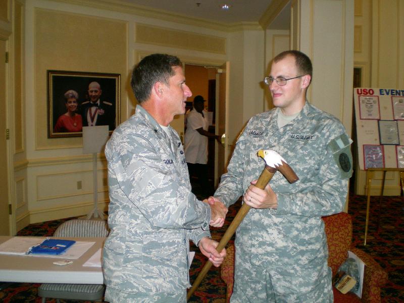 SPC Marcus LaBadie being presented his cane by BG Goldfein. Cane carved by John Helmeyer.
